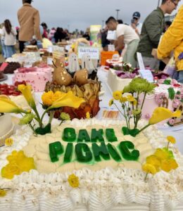 Decorated cake picnic display at an outdoor festival featuring floral designs and themed desserts on Treasure Island.