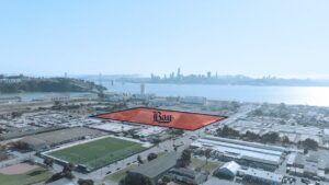 Aerial view of Treasure Island development site highlighted for Bay FC training facility with the San Francisco skyline and Bay Bridge in the background.